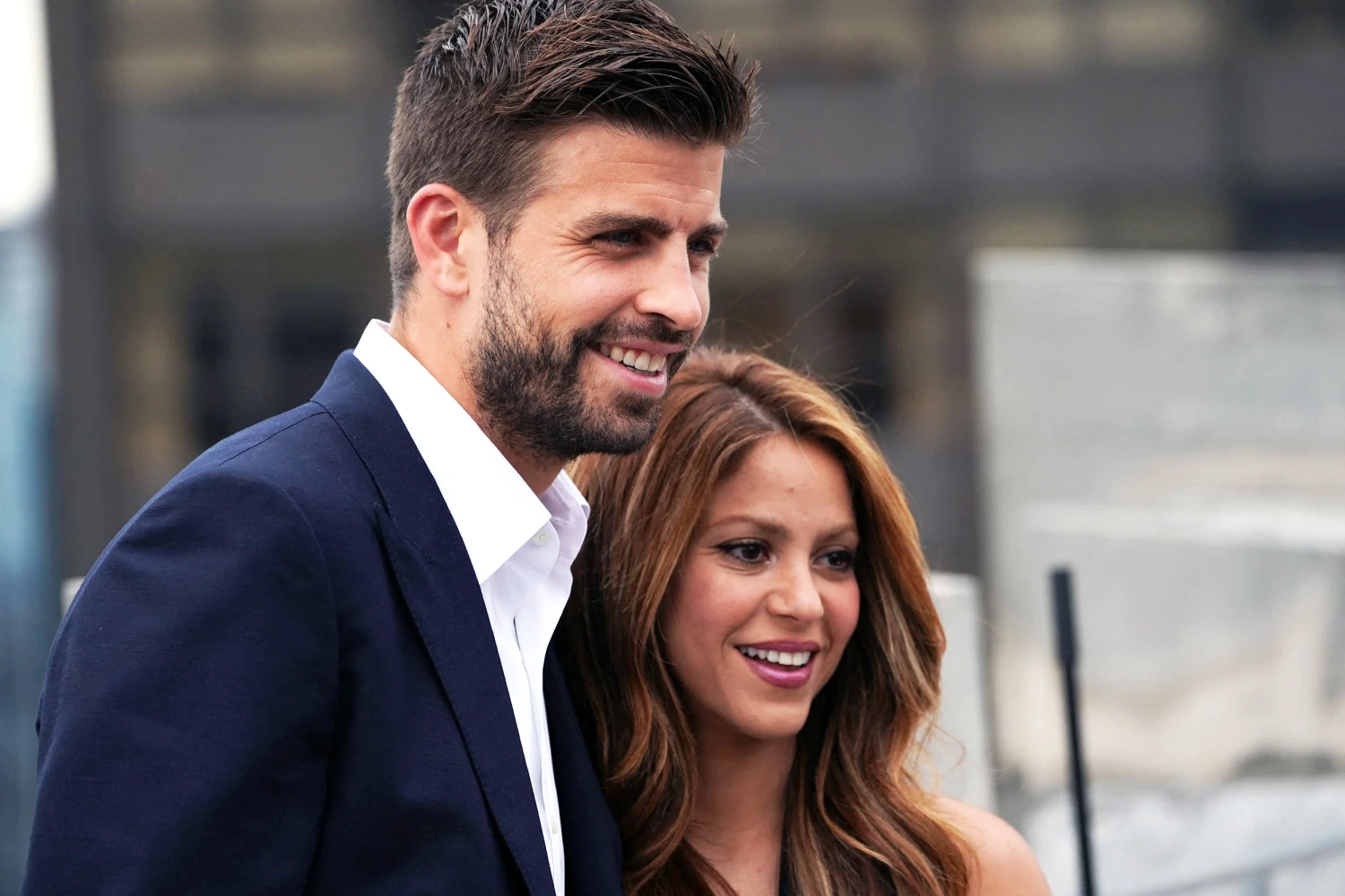A silhouetted side profile of Pique and Shakira walking hand-in-hand, with their past relationship intersecting the background like a timeline of their love story.